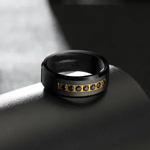 Macro detail of men's black tungsten ring with gold channel set black cubic zirconia