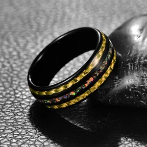 Gros plan sur une bague en tungstène noir avec fibre de carbone dorée et opale