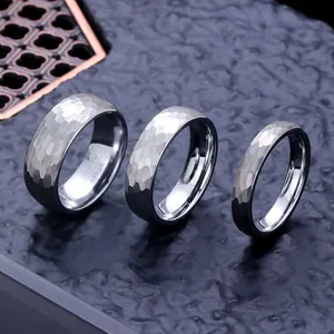 Primer plano de tres anillos de carburo de tungsteno con un acabado martillado único.