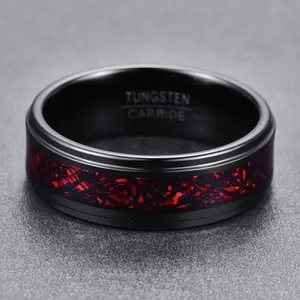Macro detail of an 8mm black tungsten carbide ring featuring a red dragon inlay