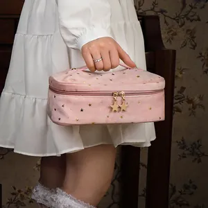 Elegant pink velvet makeup bag featuring gold star patterns and a portable handle.