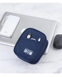 Close-up detail of a navy blue electronics organizer bag placed on a laptop with cables