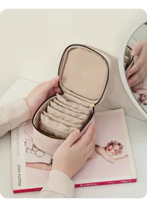 Detail view of portable beige leather jewelry organizer with mini zipper pouches
