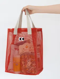 Red breathable mesh beach tote bag with cute eyes embroidery, hand-held detail view