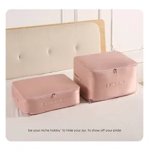 Detail of two pink fabric storage bags for quilts and clothing on a bed.
