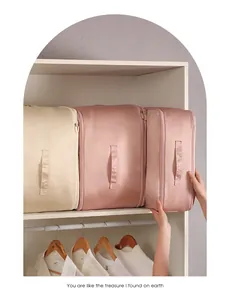 Beige and pink fabric storage bags for clothes organized on a white closet shelf