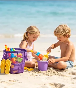 Niños jugando en la playa con juguetes y un gran bolso de malla violeta bajo el sol