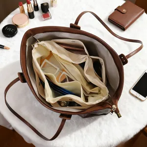 Organiseur de sac crème polyvalent avec plusieurs compartiments dans un grand sac en cuir marron