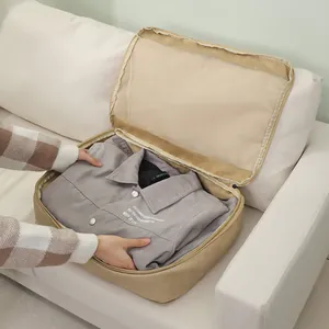 Large capacity beige travel storage bag with mesh top for clothing organization