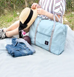 Große hellblaue faltbare Reisetasche, dargestellt in einer Outdoor-Lifestyle-Umgebung