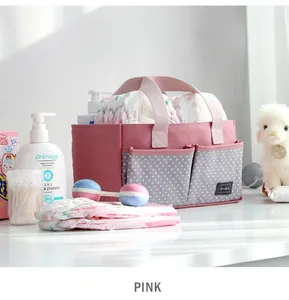 Roze luiermandje voor baby's met grijze sterzakken en babybenodigdheden.