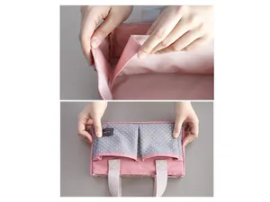 Gedetailleerde weergave van roze kinderwagen organizer met klittenband en zakken.
