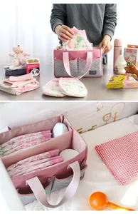 Roze luierorganizer voor baby's met verschillende zakken en binnenruimte.