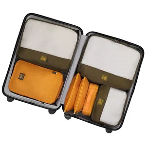7-piece travel packing cube set in olive green and yellow organized in suitcase