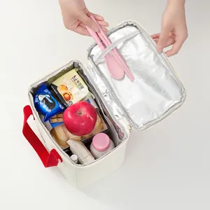 Large capacity thickened thermal lunch bag being filled with food for commute