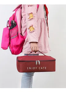 A child holding a burgundy insulated Oxford cloth lunch bag with ENJOY CATE print
