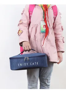 Portable navy blue insulated lunch bag being carried by a child