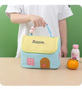 Detailed view of cute house-shaped insulated lunch bag being held by a practical handle.