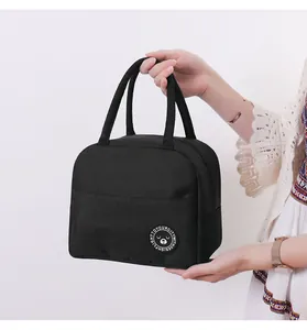 Detailansicht der schwarzen isolierten Lunchtasche mit süßem Bären-Patch, von einem Model gehalten.