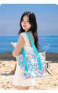 Modell mit holografischer PVC-Strandtasche und Smiley-Muster an einem sonnigen Strand