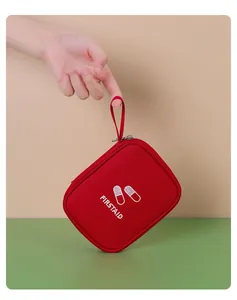 Détail d'une pochette de premiers secours rouge avec dragonne de transport