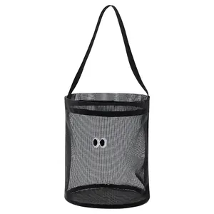 Portable black mesh bucket bag with cute embroidered eyes, perfect for beach trips.
