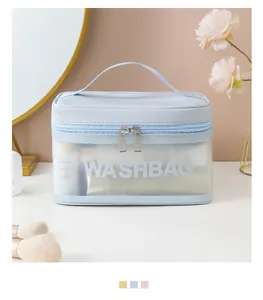 Grande borsa da toilette da viaggio in PVC azzurro su un tavolo da trucco con manico