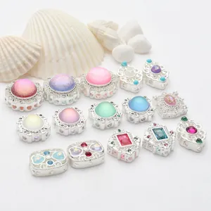 Vista detallada de cuentas plateadas con piedras de colores para joyería DIY única.