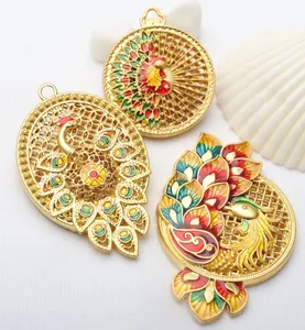 Detail of ornate ancient gold hollowed peacock pendants with colorful enamel accents