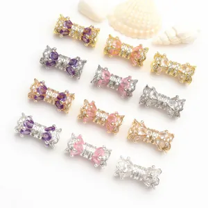 Close-up of elegant bow-shaped jewelry clasps with colorful zircons in various finishes