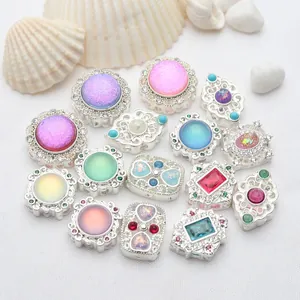 Primer plano de varias cuentas plateadas con incrustaciones de piedra para joyas DIY