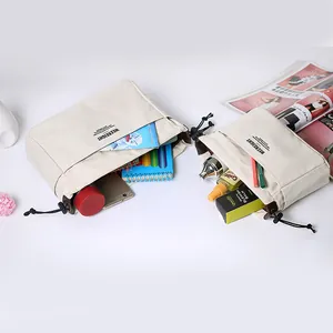 Deux sacs organisateurs en toile à cordon avec plusieurs poches pour maquillage.
