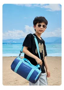 Asian boy carrying a stylish blue waterproof swimming bag at a sunny beach resort