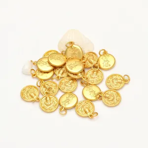 Detailed view of antique gold-toned round pendants with traditional Chinese engravings for DIY