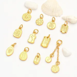 Macro view of gold-colored DIY charms with intricate Taoist and constellation engravings.