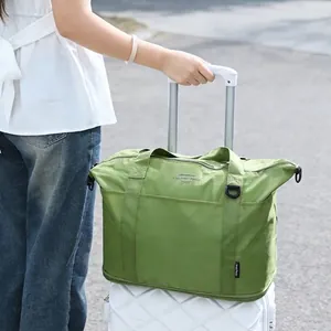Opvouwbare groene reistas met grote capaciteit op een koffer voor extra bagageruimte