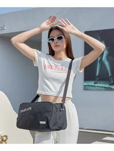 Asian female model wearing a black large capacity gym bag for travel and fitness.
