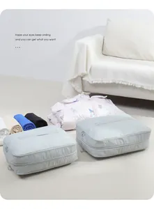 Large grey travel compression bags for organized clothing storage in a home setting