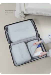 Close-up detail of light grey travel packing cubes organized inside an open suitcase