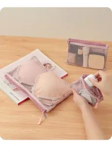 Detail view showing three sizes of pink double-layer mesh storage bags for travel cosmetics