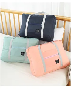 Close-up of three colorful portable travel storage bags placed neatly on a bed
