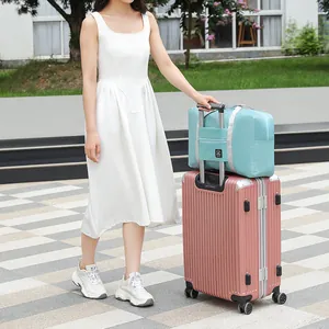 Large blue portable travel duffel bag with luggage sleeve shown on a pink hardshell suitcase