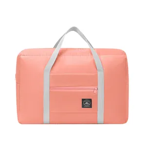 Coral pink travel duffel bag with grey handles and luggage sleeve for suitcase attachment