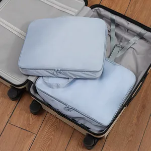 Two light blue compression packing cubes inside an open suitcase for travel organization