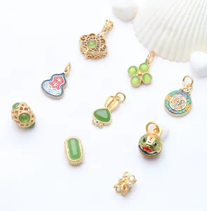 Assortment of gold-plated jewelry charms with green stones and colorful enamel details.
