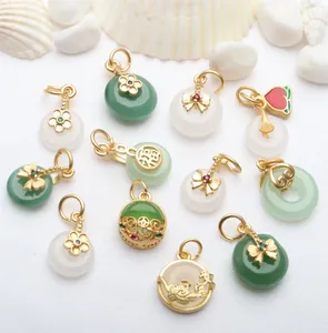 Detail view of assorted gold-tone pendants with green and white jade-like stone accents