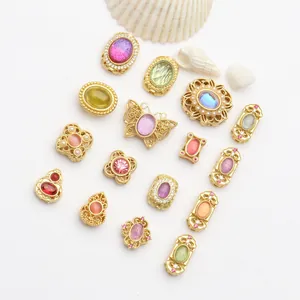 Assortiment de breloques en or vintage avec pierres œil de chat colorées pour bijoux.