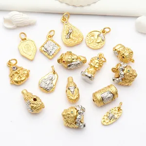 Close-up macro view of gold-plated Buddhist charms with intricate details for DIY jewelry