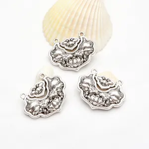 Detailed view of three retro silver goldfish and lotus charms for DIY jewelry making crafts.