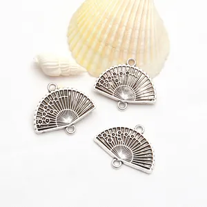 Detailed view of antique silver fan-shaped charms with delicate plum blossom design